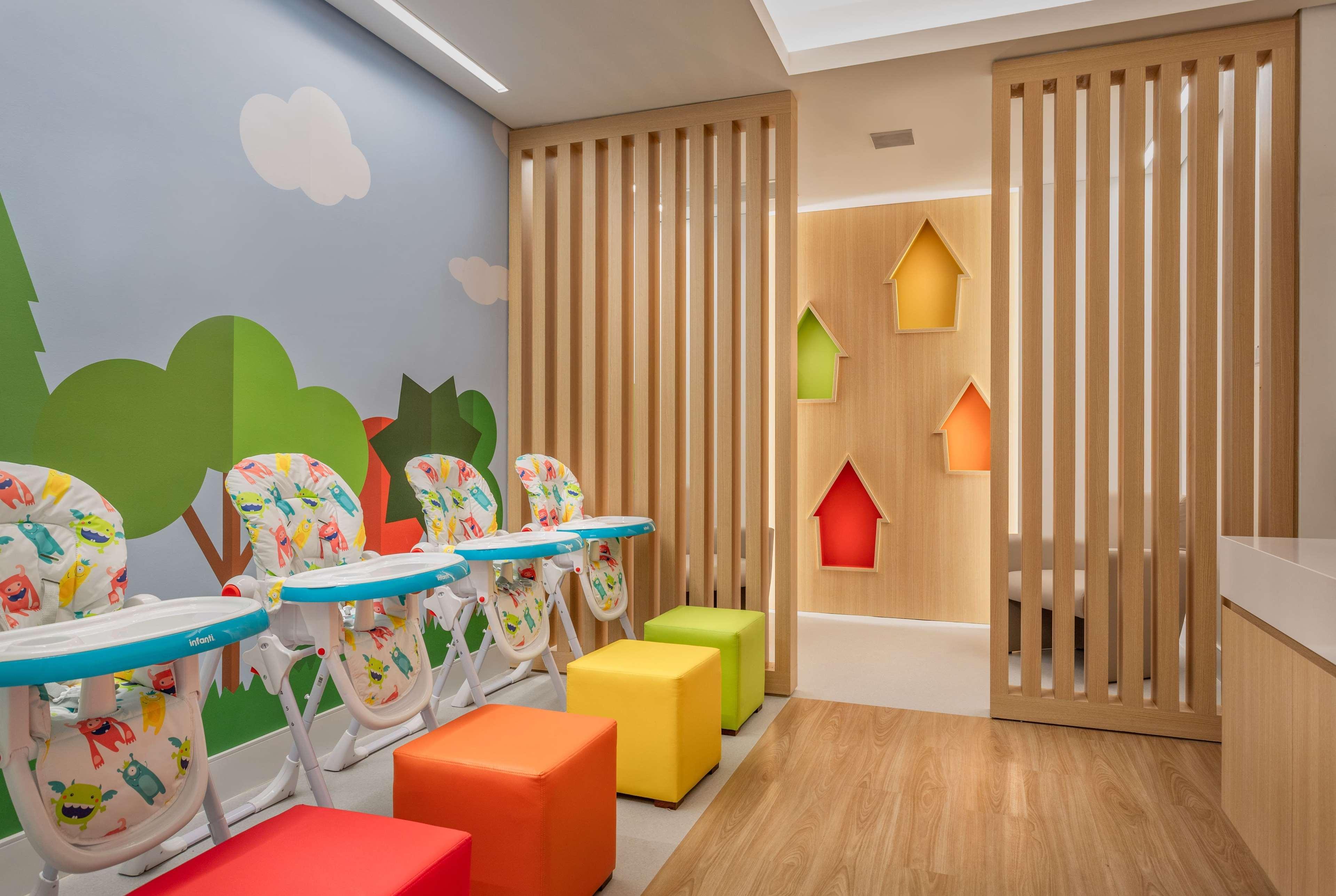 Wyndham Gramado Termas Resort & Spa Екстер'єр фото The photo shows a brightly colored, child-friendly room designed for young children. On one side, there are several high chairs with playful designs, indicating it's a space for feeding or play. The walls are decorated with cheerful illustrations of 